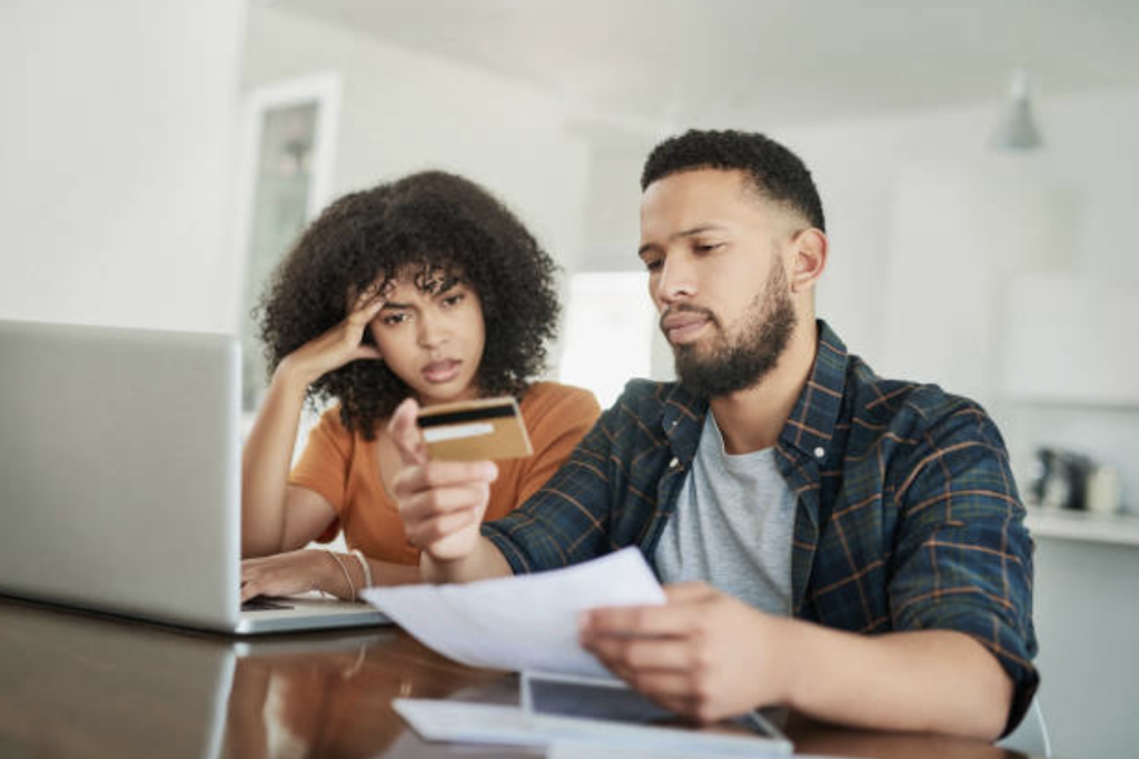 Couple paying off credit cards at table