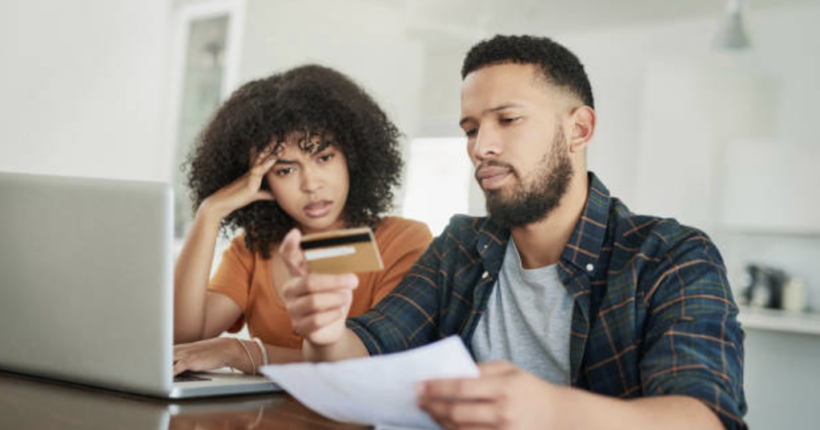 Couple paying off credit cards at table