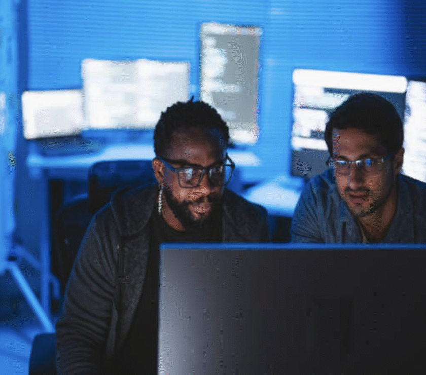 Cybersecurity professionals monitoring network security on multiple screens.
