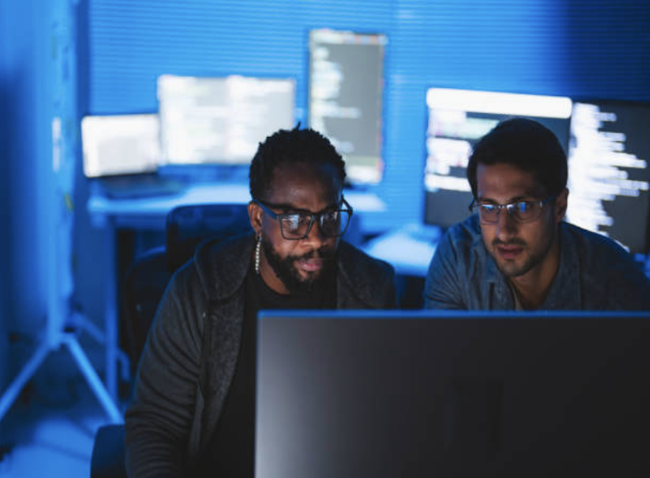 Cybersecurity professionals monitoring network security on multiple screens.