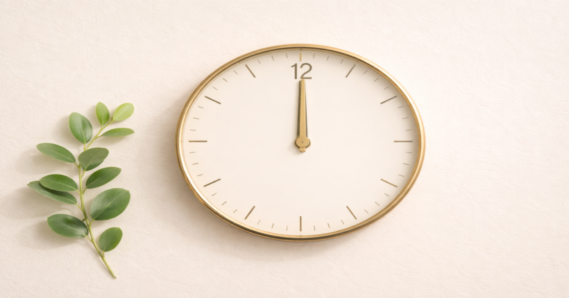 An analog clock face beside a small green plant on a clean cream surface, representing the time it takes to build a 700 credit score — a 12 to 24 month process driven by consistent payment behavior and the right credit tools