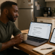 Man managing career work and a side hustle project on two screens at a home table, representing the balance between primary employment and supplemental income
