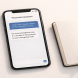 Smartphone showing a chat-style AI financial assistant interface beside an open notebook and pen on a light desk surface