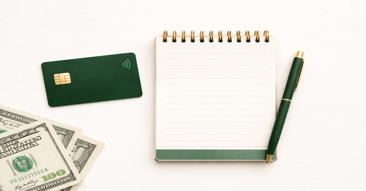 A debit card, open budget notebook, and cash on a clean surface representing the first financial decisions of early adulthood — first bank account, first budget, first savings habit