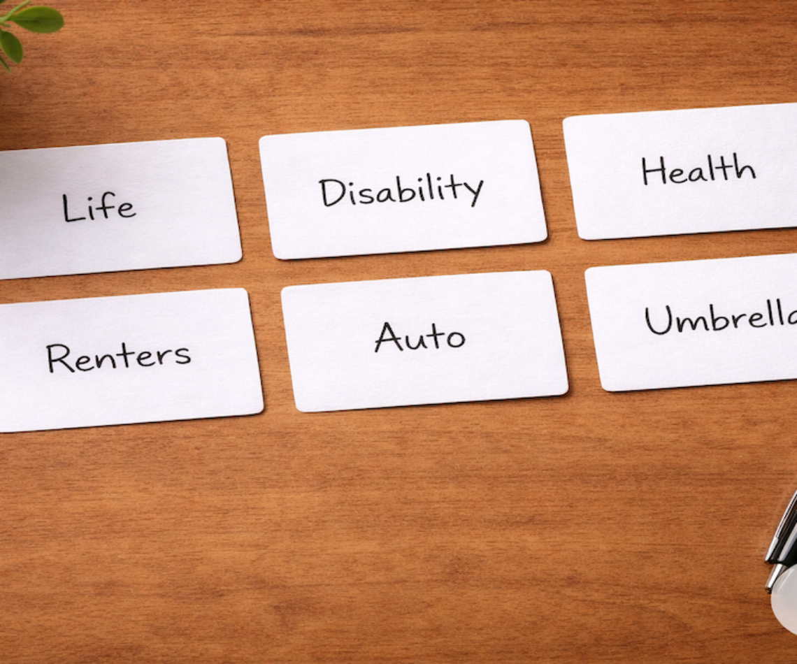 Six labeled insurance coverage cards reading Life, Disability, Health, Renters, Auto, and Umbrella arranged on a warm wood surface — PersonalOne