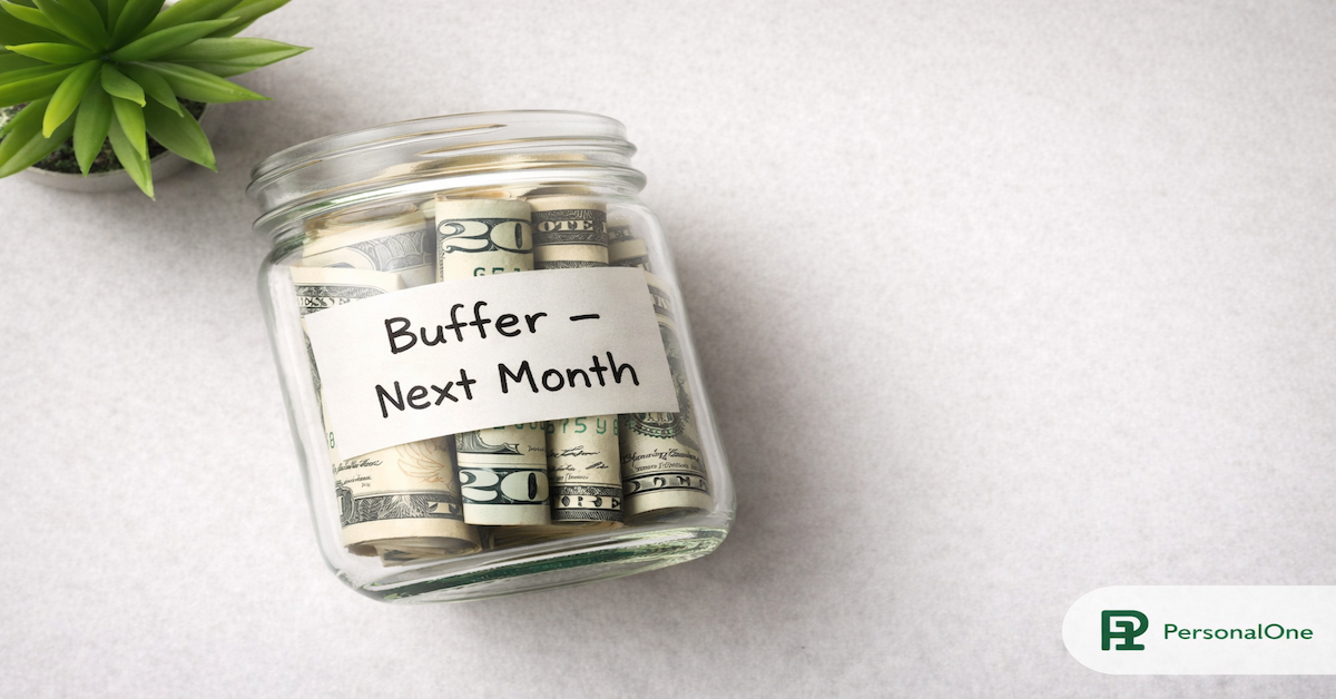 Glass jar two-thirds full of rolled bills labeled Buffer Next Month on a light gray surface — PersonalOne