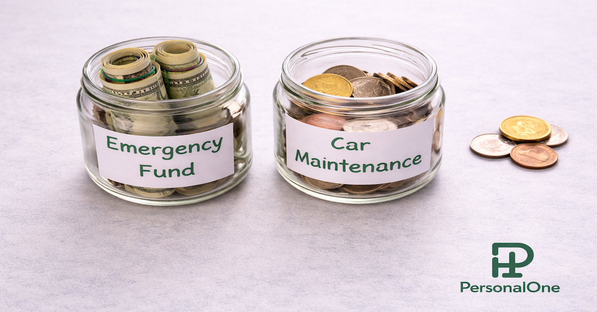 Two labeled glass jars side by side on a light gray surface — one reading Emergency Fund and one reading Car Maintenance with scattered coins nearby