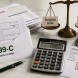 1099-C tax form, calculator, and debt settlement paperwork on a desk illustrating debt settlement tax consequences and taxable forgiven debt income